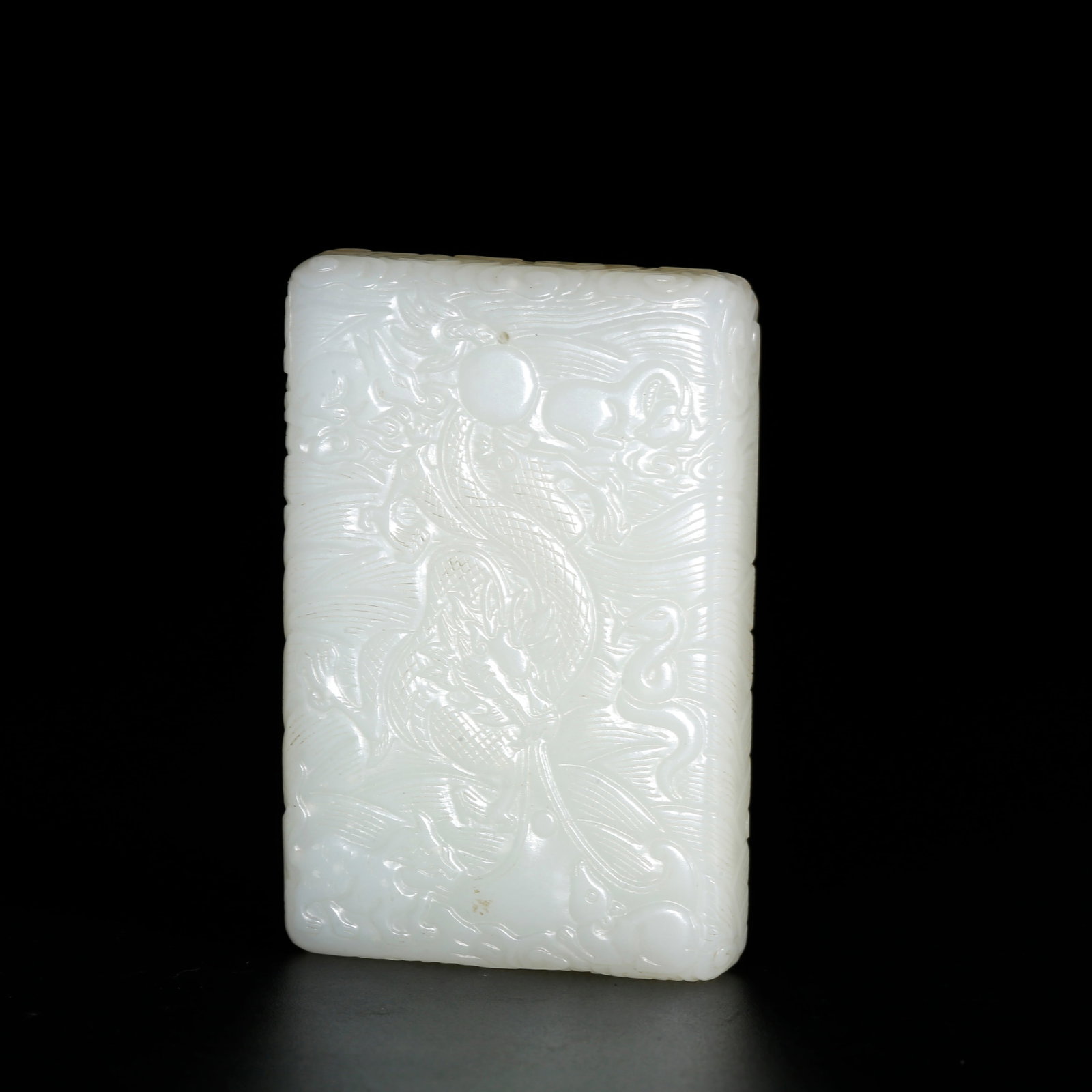 A HETIAN JADE PLAQUE CARVED WITH DRAGON AND SEA WAVE PATTERN: Hetian Jade Plaque Carved with Dragon and Sea Wave Pattern