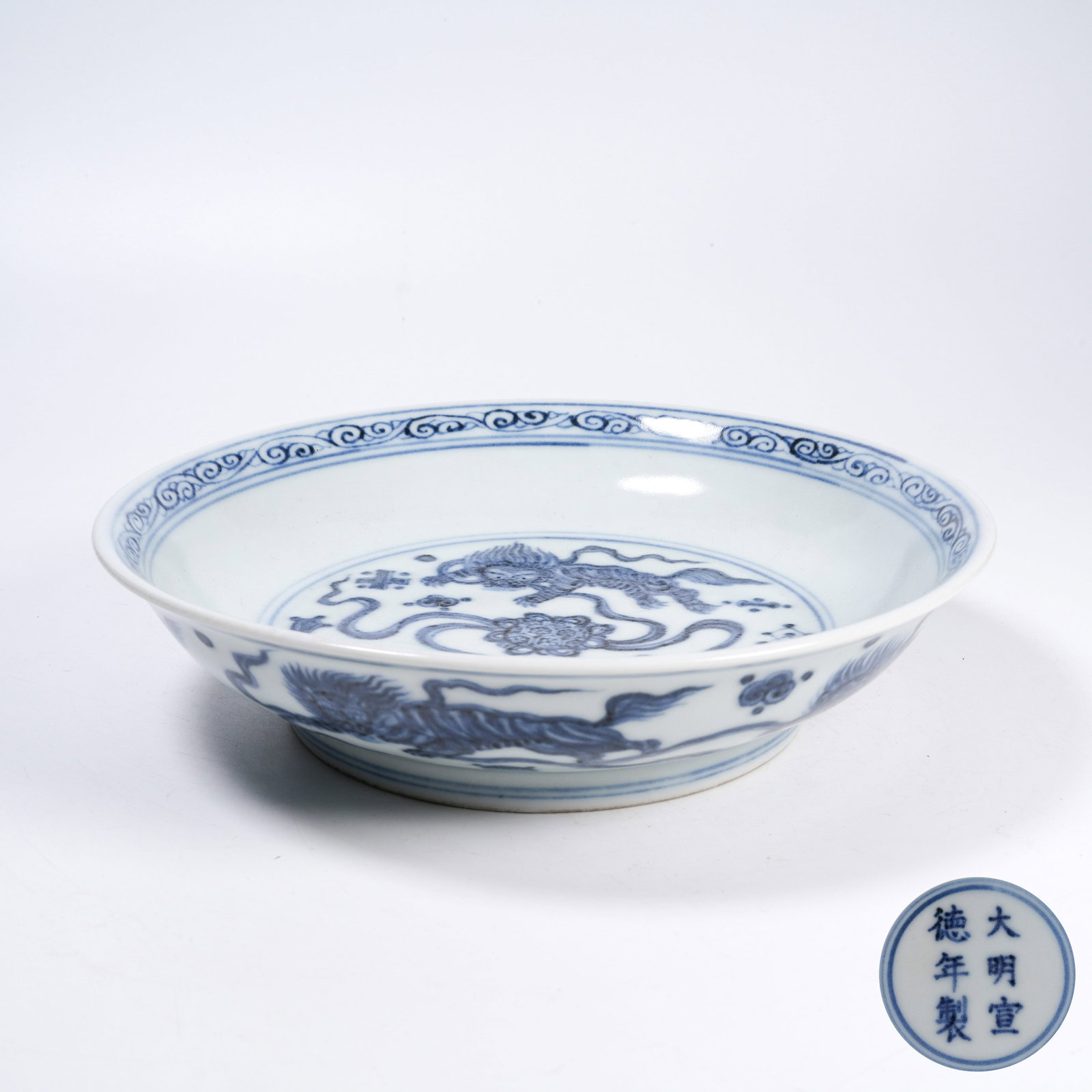 A BLUE AND WHITE PLATE WITH LION ROLLING EMBROIDERED BALL PATTERNS: Blue and White Plate with Lion Rolling Embroidered Ball Patterns