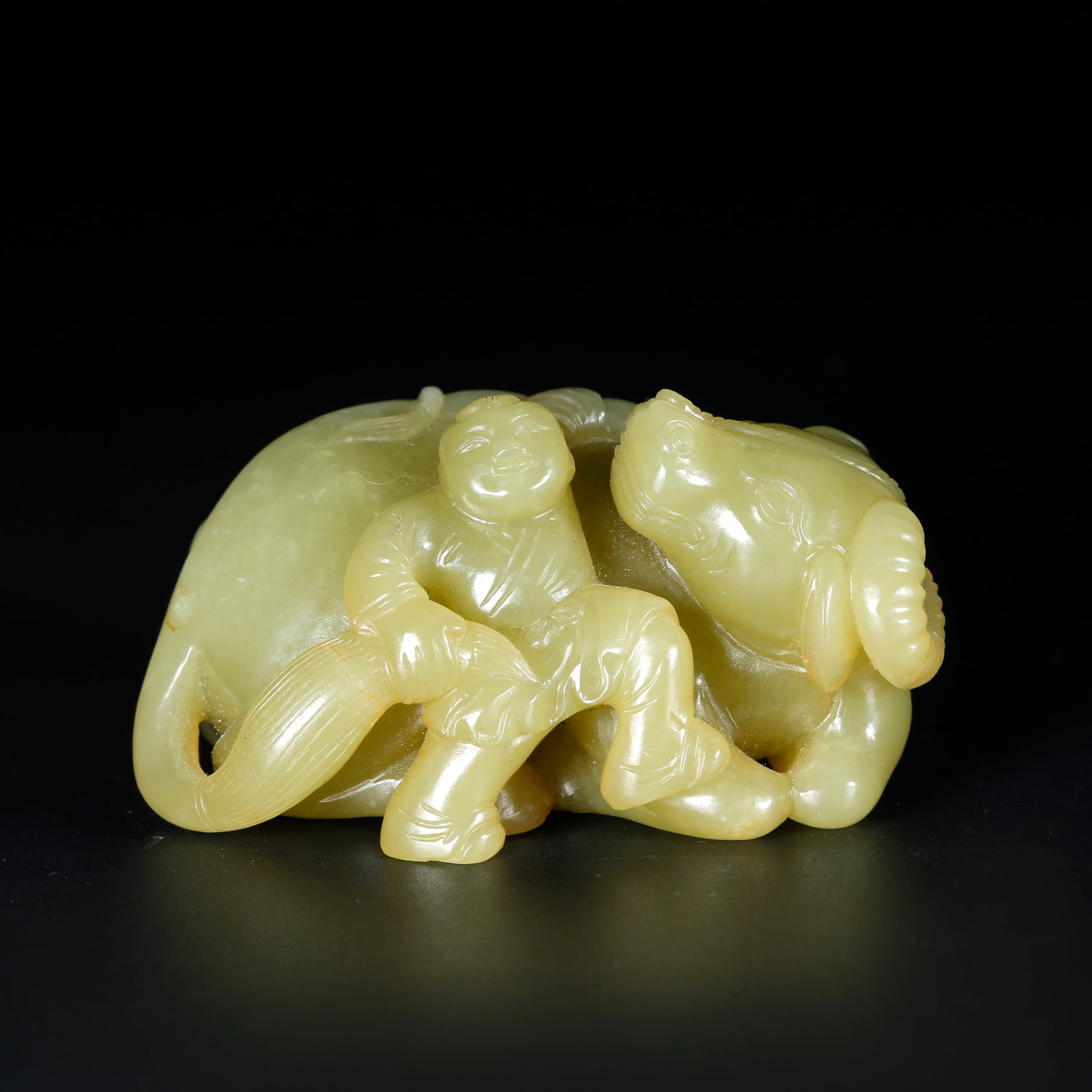 A YELLOW HETIAN JADE ORNAMENT CARVED AS CHILD HERDING OX: Yellow Hetian Jade Ornament Carved as Child Herding Ox