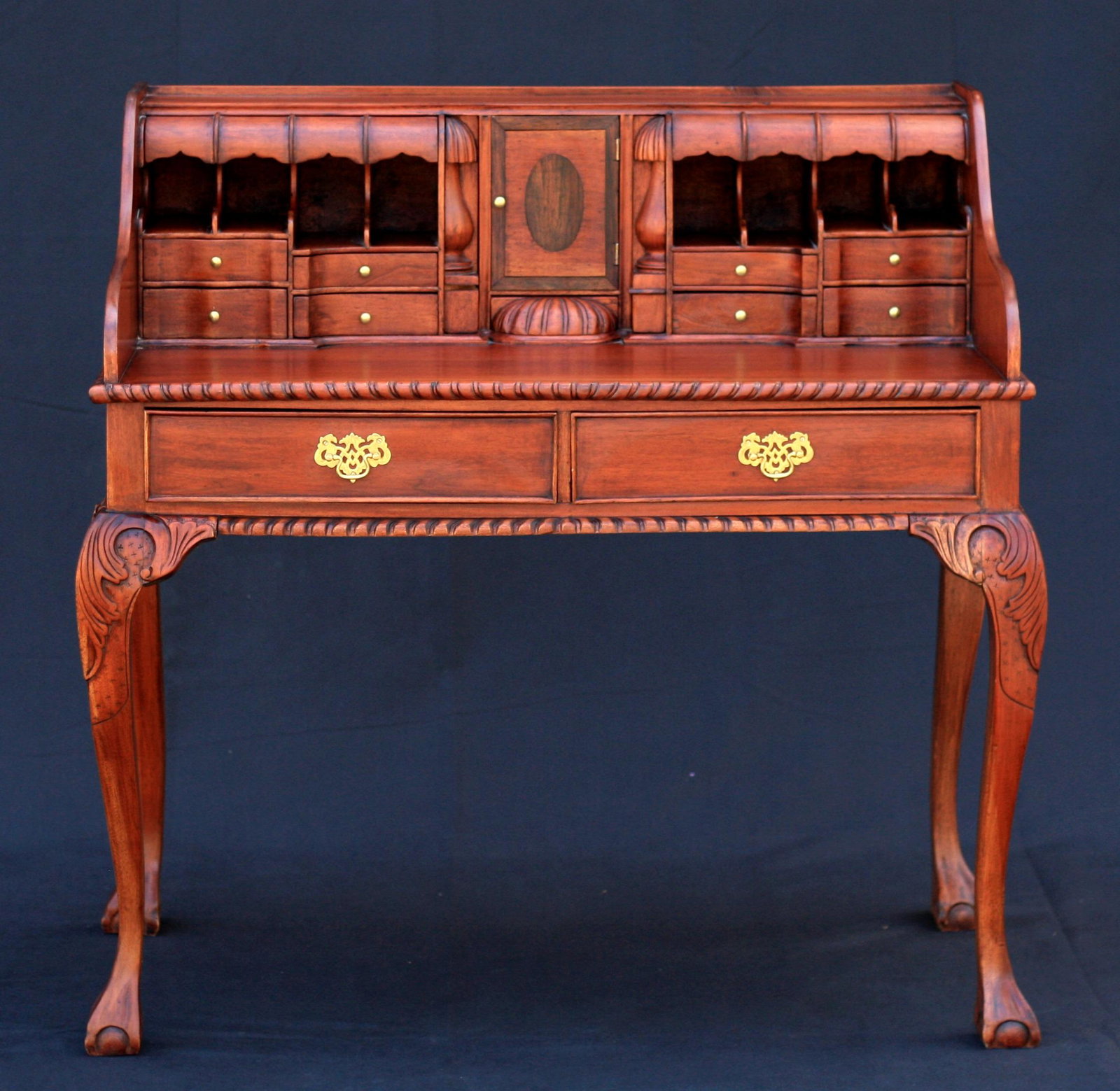 Mahogany Chippendale Secretary Desk, late 20th or early 21st Century: Well-made of solid mahogany, this secretary desk is constructed of two parts: a desk and top hutch. The hutch has various interior compartments including 7 secret compartments. The desk has two drawer