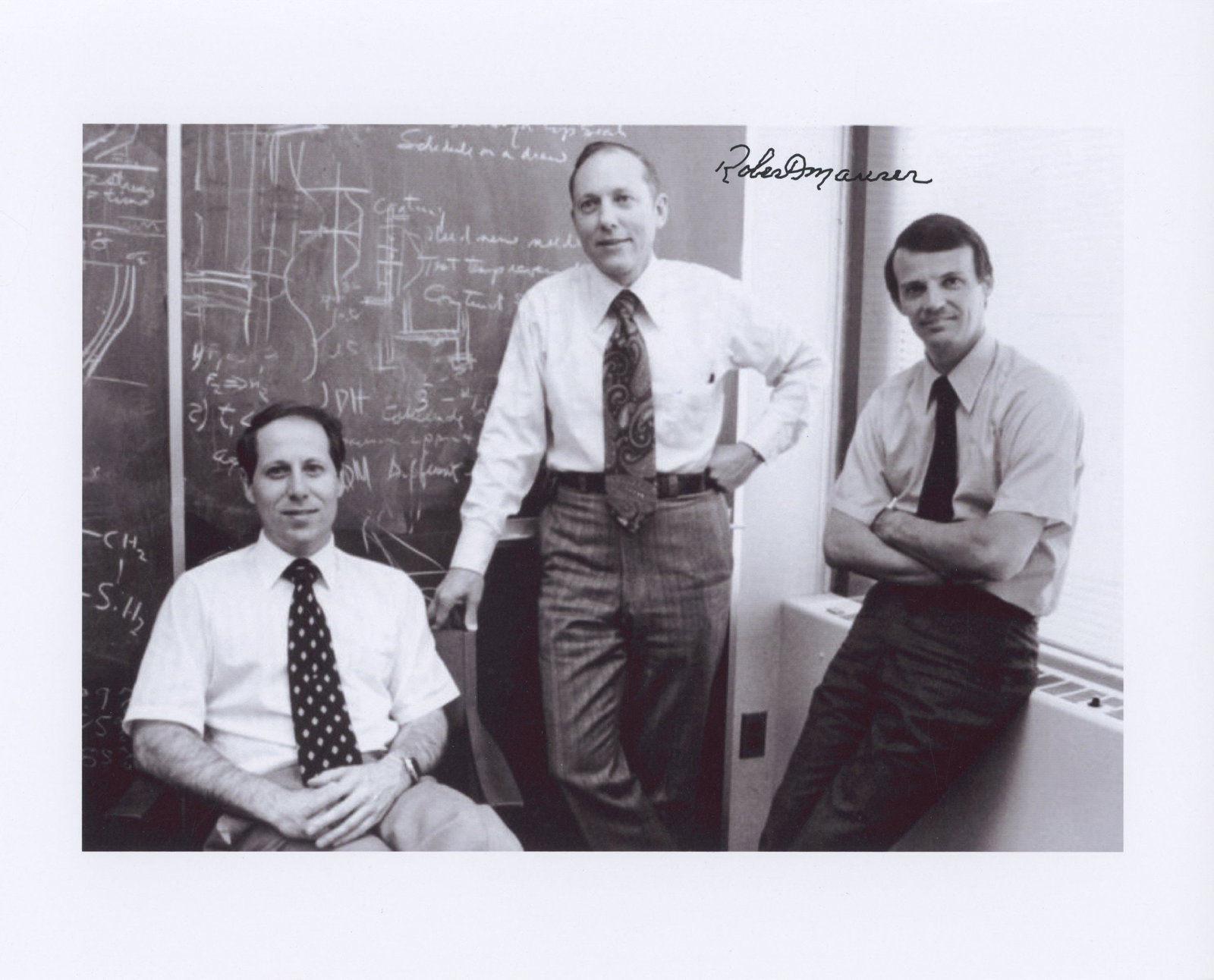 Robert Maurer – Fiber Optics Pioneer – Autographed 10 x 8 Photo – Historic Science: Details: Robert Maurer autographed 10 x 8” glossy photograph depicting a historic image of Maurer (standing center) alongside colleagues Donald Keck (seated) and Peter Schultz (right) at Corning
