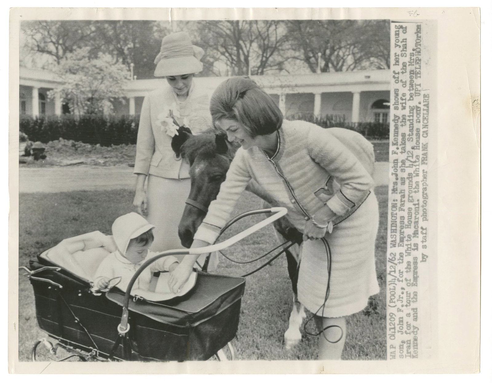 Jacqueline Kennedy & John F. Kennedy Jr. – Oversized Press Photograph – White House Grou: Details: Jacqueline Kennedy 14 x 11” original black-and-white press photograph depicting her with her young son, John F. Kennedy Jr., on the White House grounds during a public appearance. The