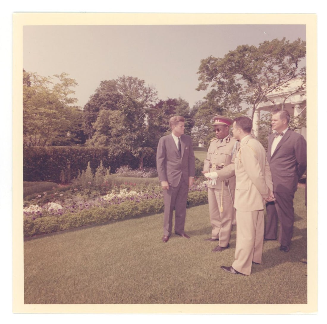John F. Kennedy – Original Cecil Stoughton 5 x 5" Photograph – White House Garden Meetin: Details: John F. Kennedy original 5 x 5” period color photograph by White House photographer Cecil Stoughton, depicting Kennedy standing on the White House grounds in conversation with visiting