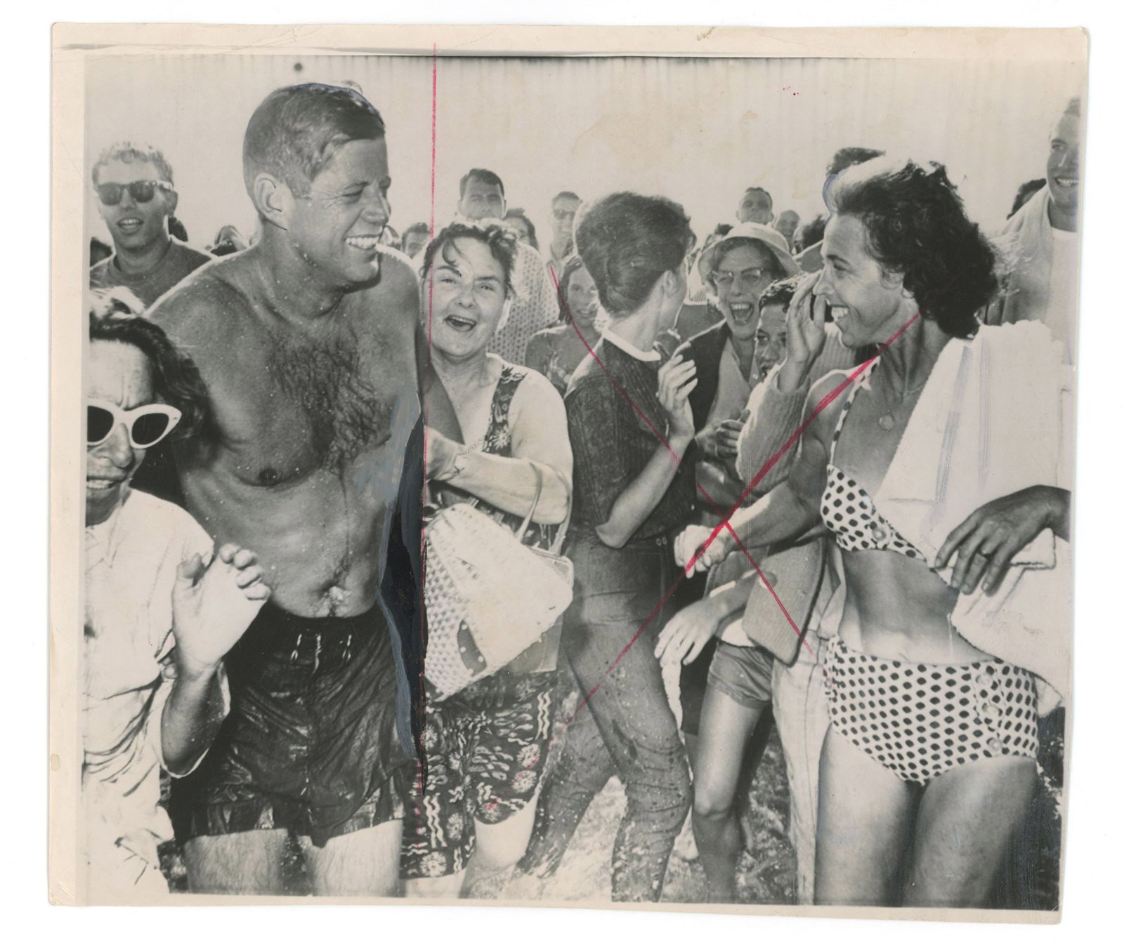 John F. Kennedy – Mobbed by Bathers During Swim – Original Press Photograph – Aug.: Details: John F. Kennedy original 8.5 x 7.25” black-and-white Associated Press press photograph depicting the President emerging from the ocean and being surrounded by onlookers during an