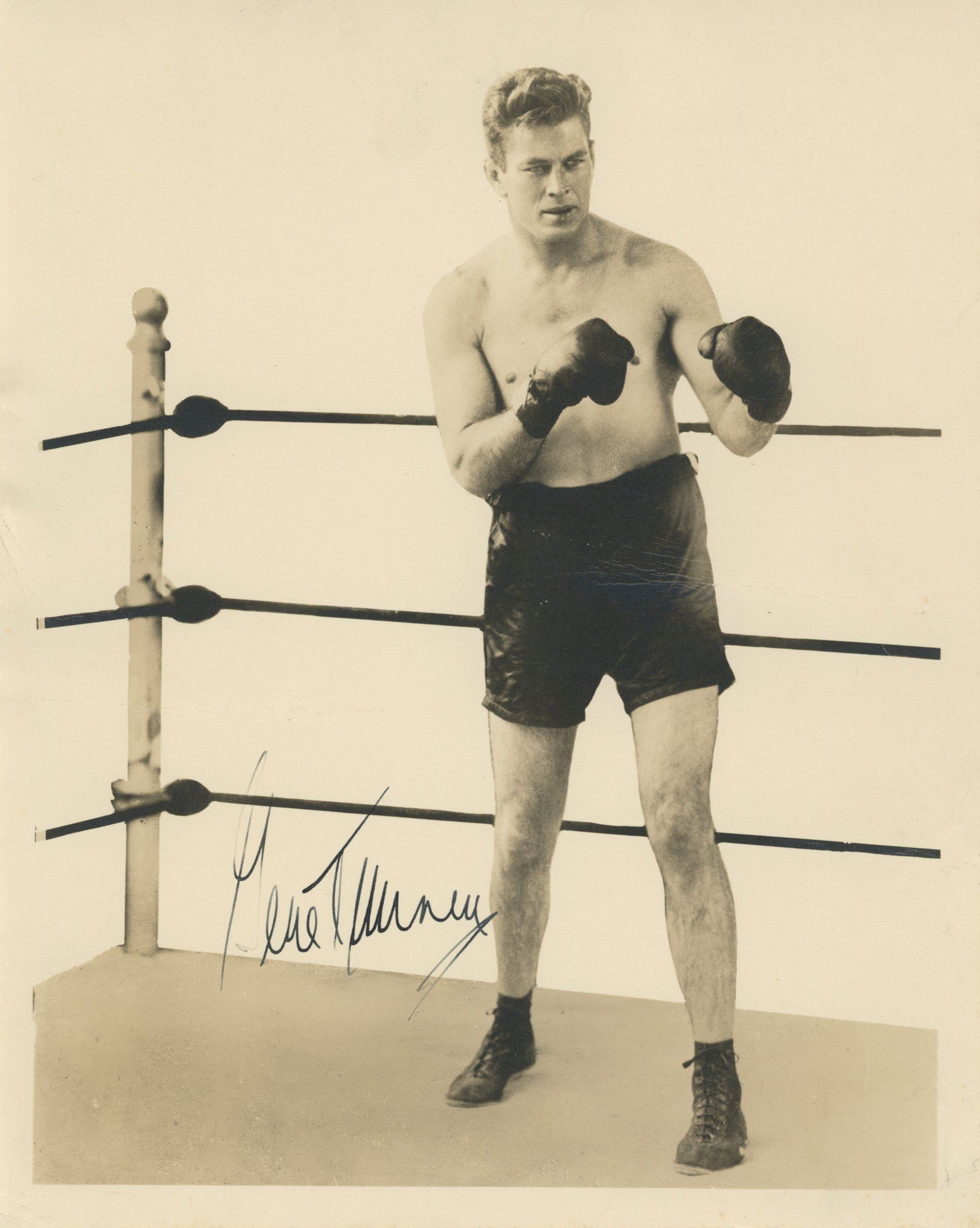 Gene Tunney – World Heavyweight Boxing Champion – Autographed 8 x 10" Photograph: Details: Gene Tunney autographed 8 x 10" black-and-white photograph showing Tunney posed in boxing stance inside the ring. The photograph is signed in dark ink along the lower portion. Fine condition