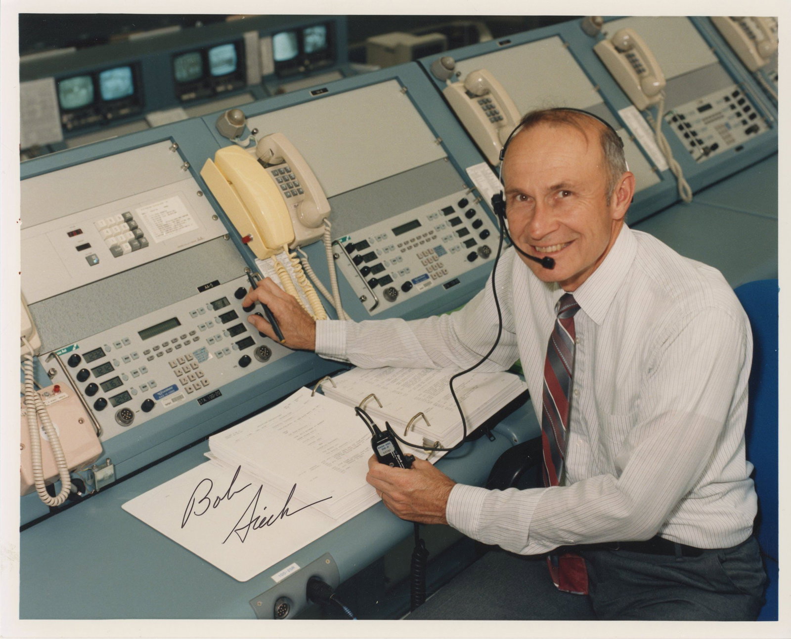 Robert B. Sieck – NASA Space Shuttle Launch Director – Autographed Photograph – 10: Details: Robert B. Sieck autographed color NASA photograph depicting Sieck seated at a launch control console inside the Kennedy Space Center, wearing a headset and surrounded by Shuttle-era