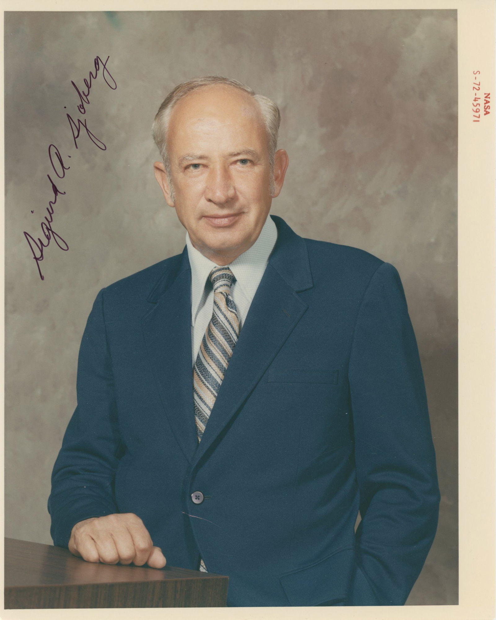 Sigurd A. Sjoberg – NASA Executive Manned Spacecraft Center – Autographed Photograph : Details: Sigurd A. Sjoberg autographed 8 × 10-inch color NASA photograph depicting the senior administrator in a formal studio portrait, posed in a professional office setting. The image