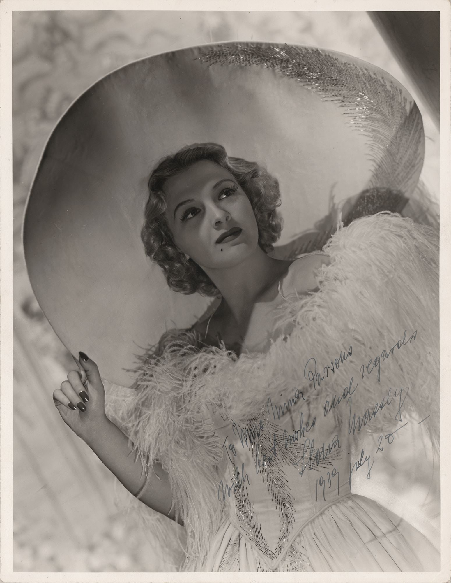 Ilona Massey – MGM Actress – Autographed 10 x 13 Photograph – Inscribed 1939 Portr: Details: Ilona Massey autographed 10 x 13” vintage matte-finish photograph depicting the actress in an elaborate costume with a wide-brimmed hat and feathered wrap, a classic Hollywood studio po