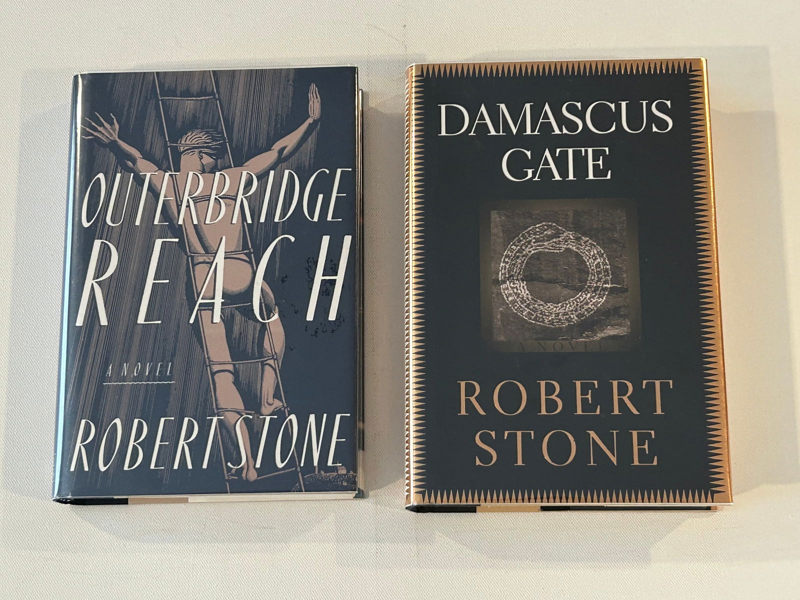 Robert Stone SIGNED First Editions: Outerbridge Reach SIGNED First Edition published by Ticknor & Fields, New York, 1992. Damascus Gate SIGNED First Edition published by Houghton Mifflin, New York, 1998 Dimensions: 11" x 9" x 6"