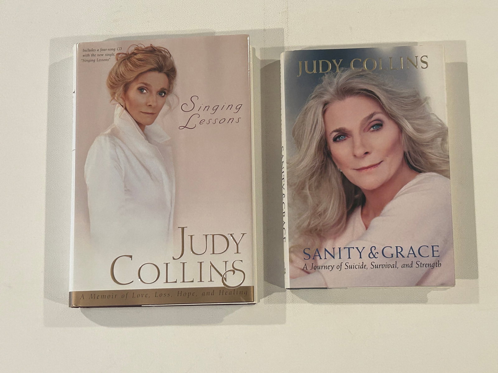 Judy Collins SIGNED & Inscribed First Editions: Singing Lessons A Memoir Of Love, Loss, Hope, And Healing SIGNED & Inscribed First Edition published by Pocket Books, New York, 1998, (small tear to jacket). Sanity & Grace A Journey Of Suicide, Survi