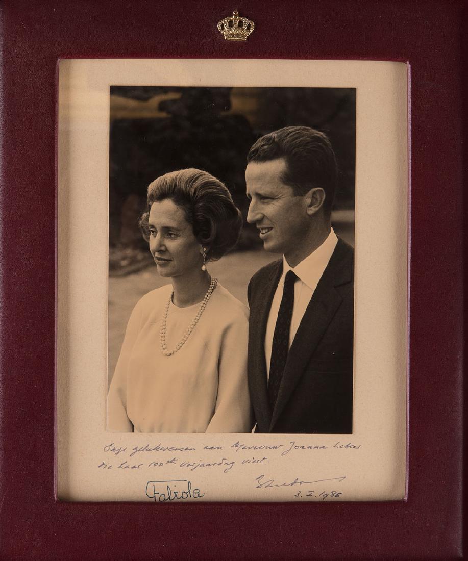 Le Roi BAUDOUIN ET LA REINE FABIOLA - Photographie noir: Le Roi BAUDOUIN ET LA REINE FABIOLA - Photographie noir et blanc signée et datée du 3.I. 1986. Dimensions approximatives: 225 x 180 mm, placée sous cadre vitré surmonté de la couronne royale et �