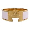 Hermes Clic Clac H Pink Enamel Gold Bracelet: This Hermes Clic Clac H bracelet features a pink enamel exterior paired with gold-tone metal accents, creating a signature and elegant look. Designed for women, it is crafted in France and showcases