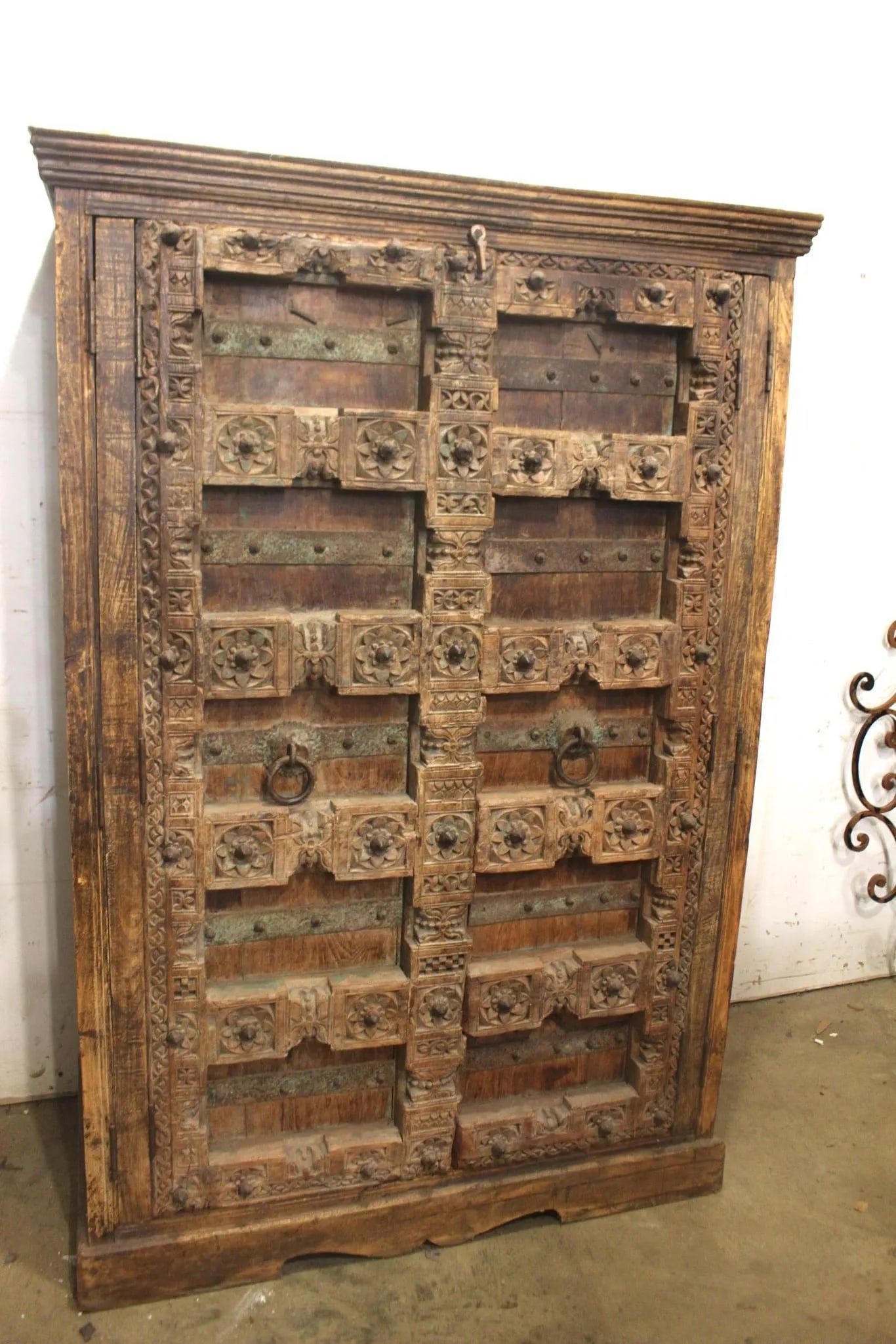 Highly Craved Spanish Colonial Doors in Cabinet: Heavily carved ancient style two door cabinet with iron hoop handles. Measuring approx 6ft tall x 4ft wide x 2ft deep. Doors appear to be much much older than cabinet itself. Cabinet is late 19th