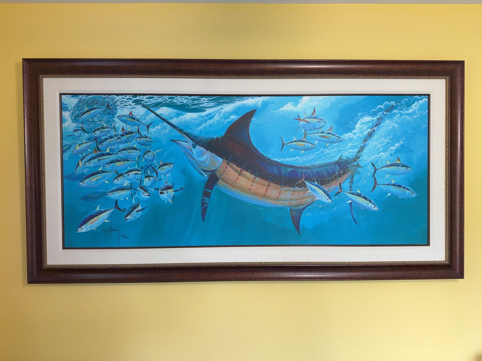 Guy Harvey "Blue Moon" Limited Edition Giclée on Canvas: Limited edition Guy Harvey giclée on canvas titled "Blue Moon," edition number 27/200. Features a blue marlin and yellowfin tuna underwater scene. Image size is 59 x 25 in. Frame size 70 X 35.25
