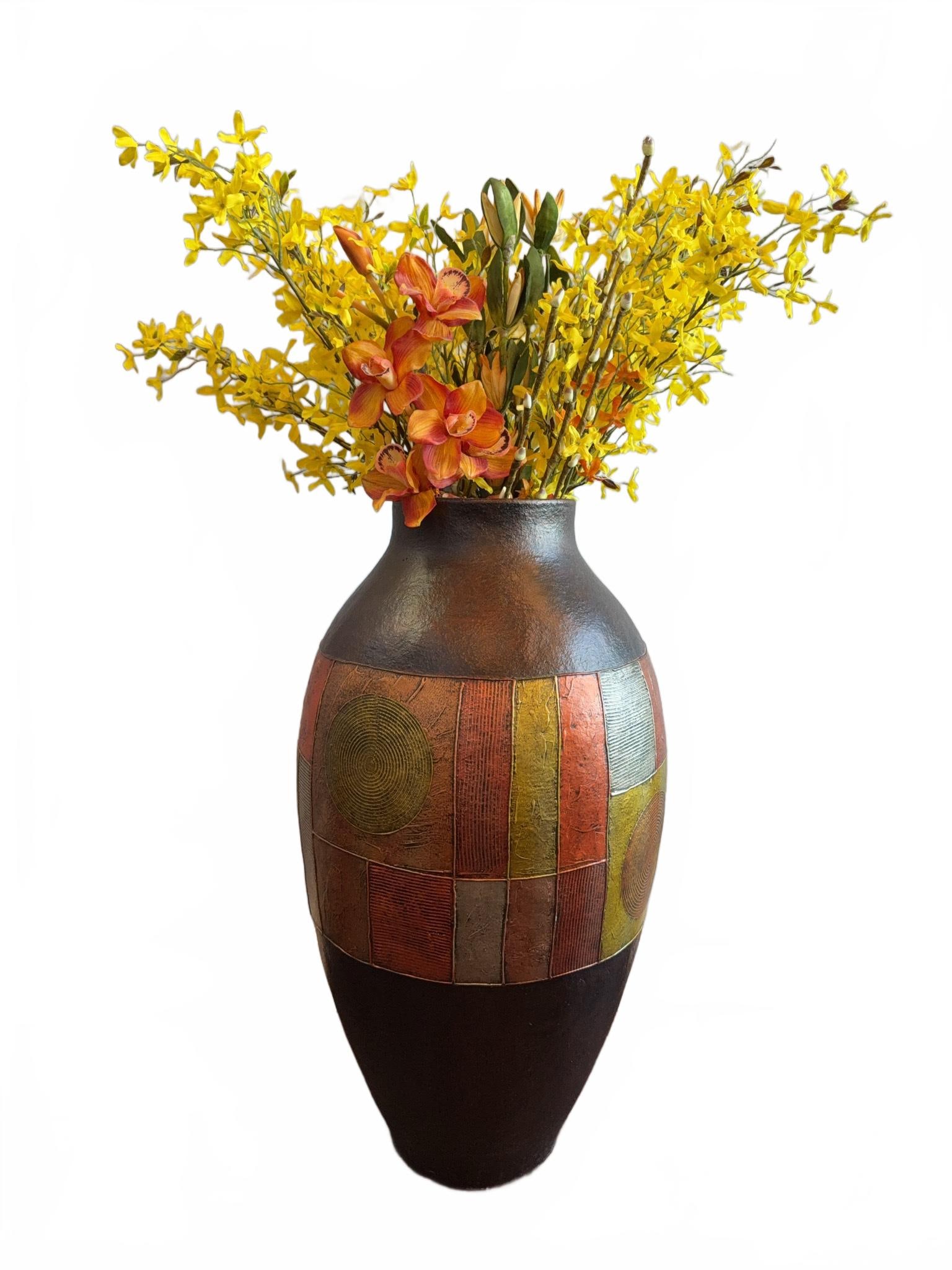 Tall Decorative Floor Vase With Geometric Motif 1 of 2: Tall decorative floor vase featuring a geometric motif in red, green, gold, and textured patterns. Vase is crafted for decorative use only (SKU 2433105) and comes with artificial yellow and orange