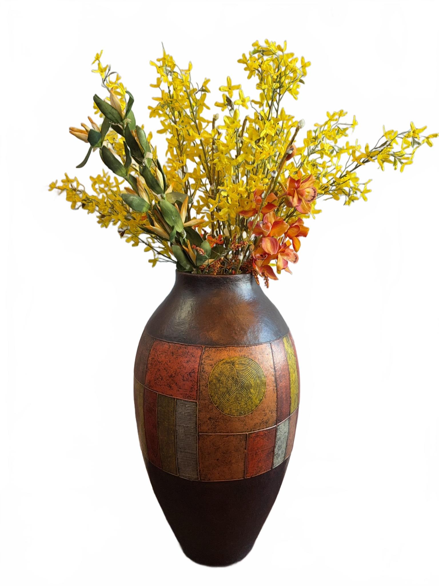Large Decorative Floor Vase With Abstract Motif 2 of 2: Tall decorative floor vase featuring geometric abstract motifs in earth tones, including circular and rectangular shapes. Includes faux yellow and orange floral arrangement. Vase has protective base