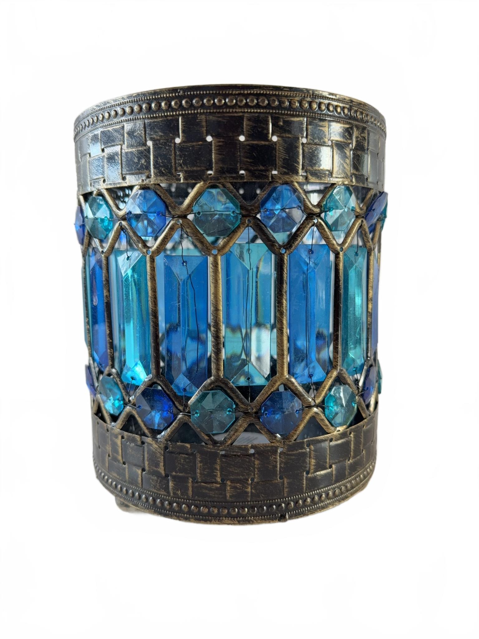 Pier 1 Blue Beaded Decorative Candle Holder 2 of 2: Pier 1 decorative candle holder featuring blue and aqua glass beads set in a metal frame. The cylindrical holder has a textured metal surface and three ball feet. Suitable as a decor accent for tealig