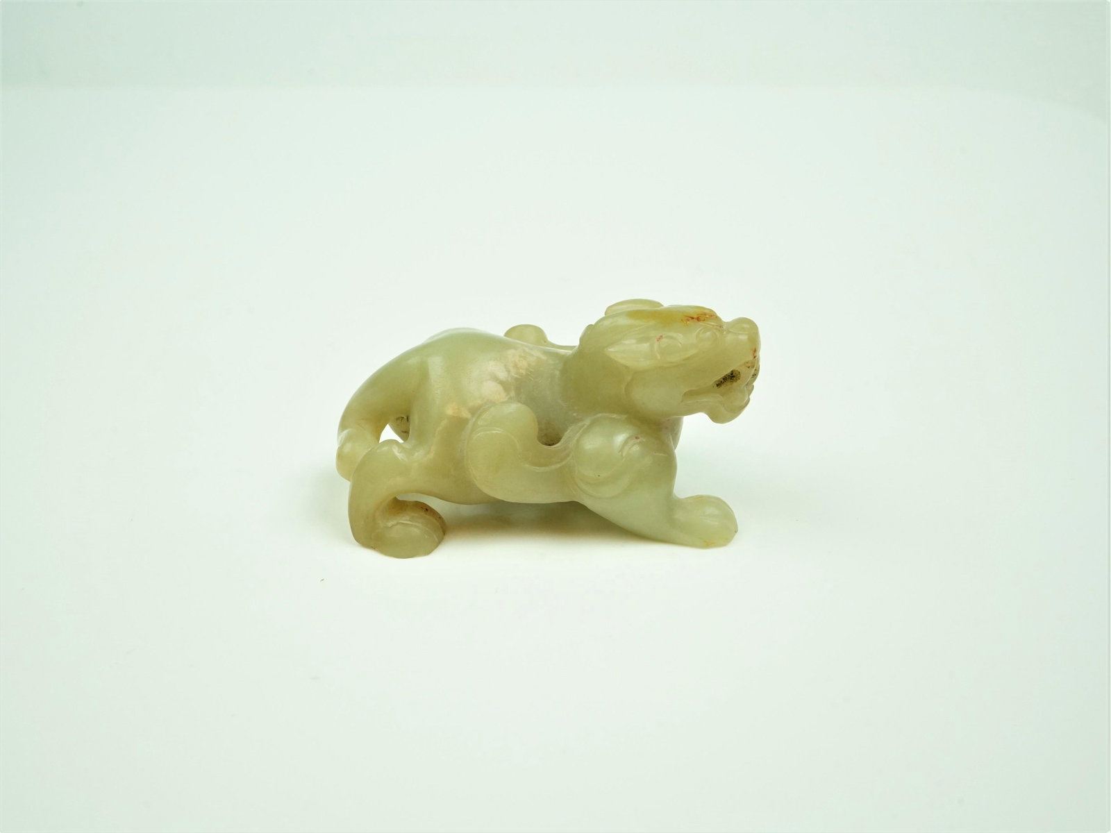 A Green and Russet Jade Carving of A Mythical Beast, Qing Dynasty: Origin: China Date/Period:18-19th.c Material:Jade Approximate Size:Length:3 3/4in Height:1 3/4in Condition: Offered in overall good condition.Surface wears,with age and use.Please refer to the picture
