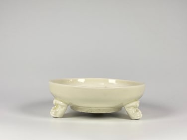 A Chinese Monochrome Cream-Glazed Tripod Censer