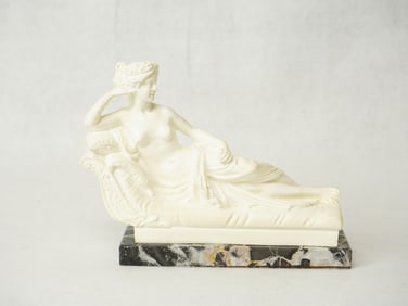 A Carved Woman Sculpture on Marble Stand