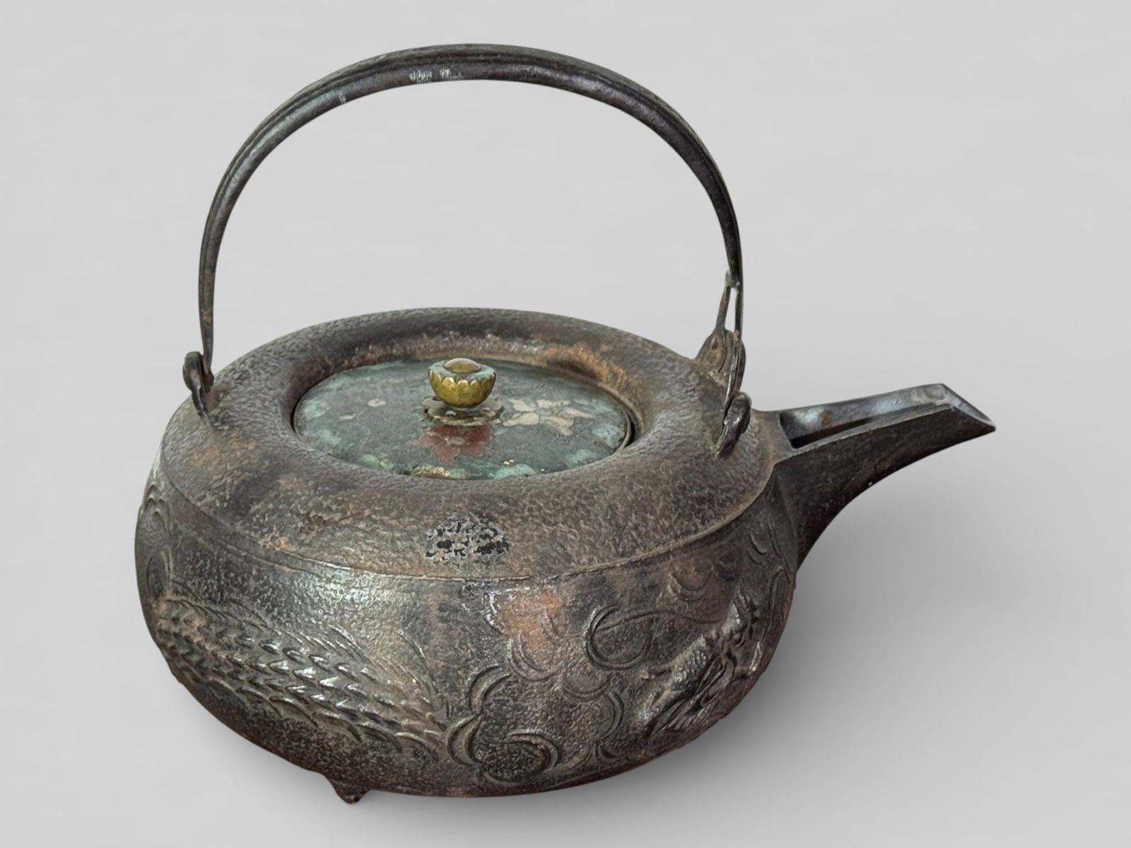 Japanese Iron Teapot With Cloisonne Cover: Japanese iron teapot with dragon motif, cover is cloisonne Enamel, mouth spout interior with silver liner, 8"w 6"ht, Enamel looses on cover as seen in photo Shipping: We offer in-house shipping servic