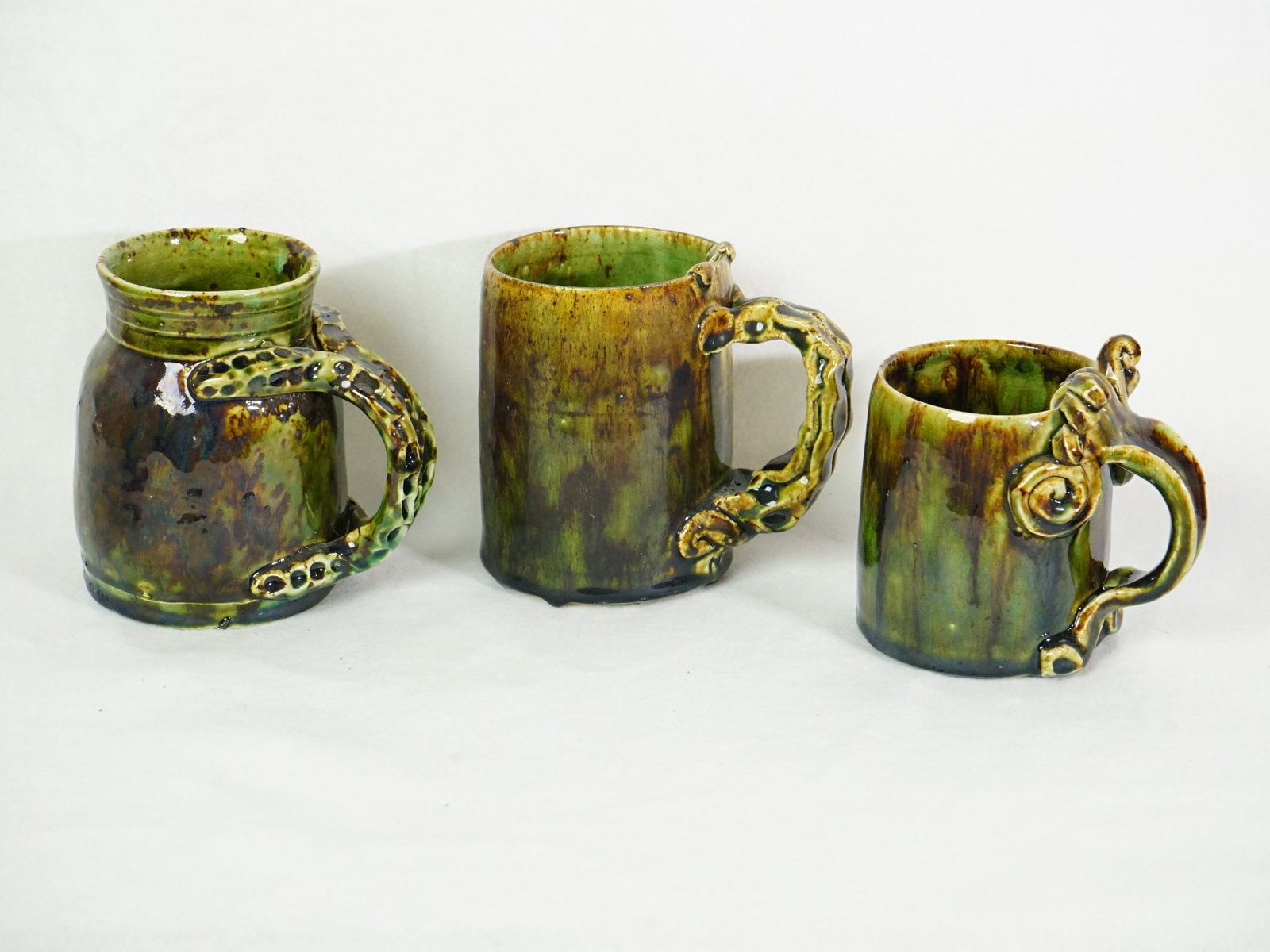 Three Studio Pottery Vessels with Fantasy Creature Motifs: Approximate size:largest 5x5.25x3.75 in,smallest 2.5x4.75x4.25 in Shipping: We offer in-house shipping services for most small items. This means that we will take care of packing and shipping the