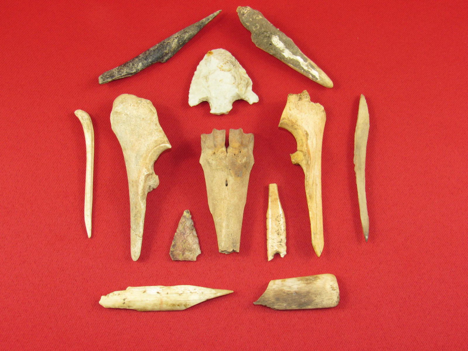 Twelve Prehistoric Indian Arrowheads Bone Tools: Twelve prehistoric Indian artifacts including ten bone tools and two projectile points from an old estate collection in Indiana. The bone piece with the penny on it appears to have been glued back tog