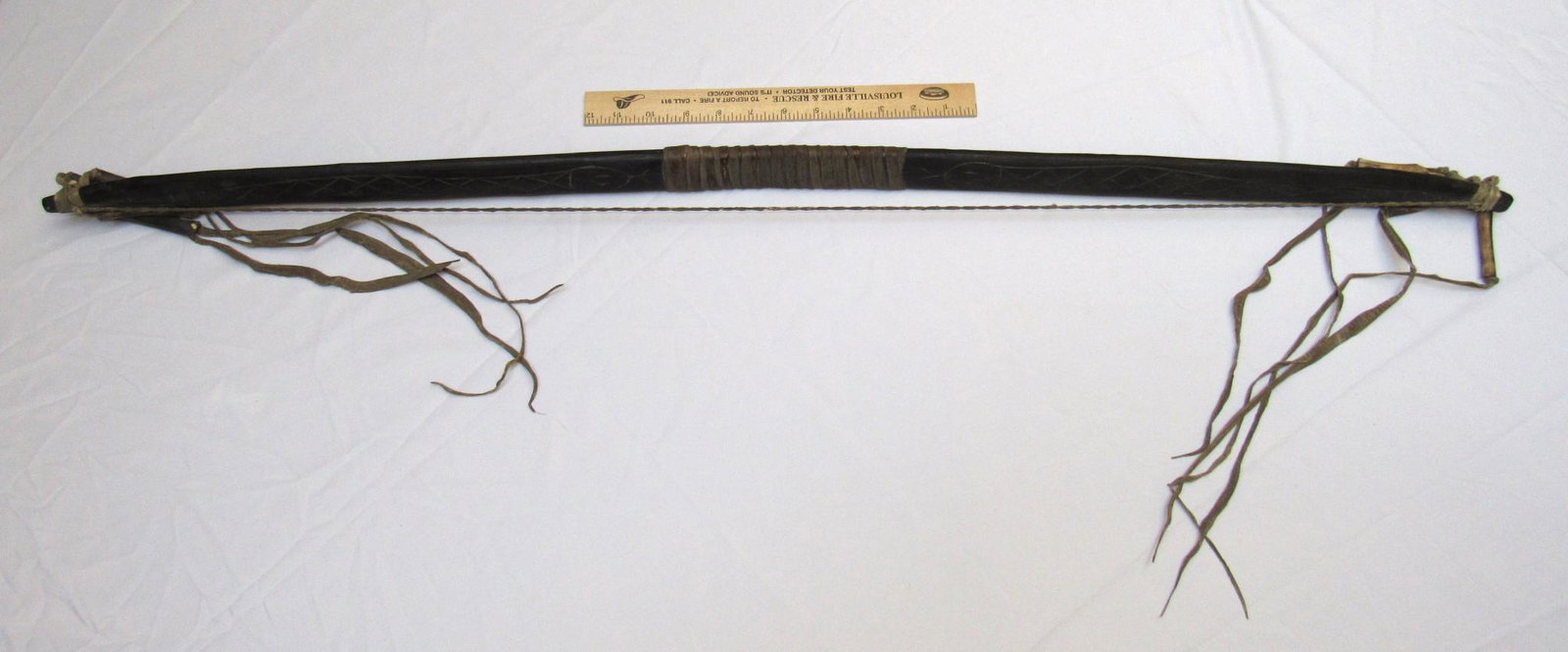 Native American Plains Indian Wooden Bow: Native American Plains Indian wooden bow. This example has a snake motif carved on one side and appears to be in good condition (see photos for additional detail). The bow is also embellished with raw