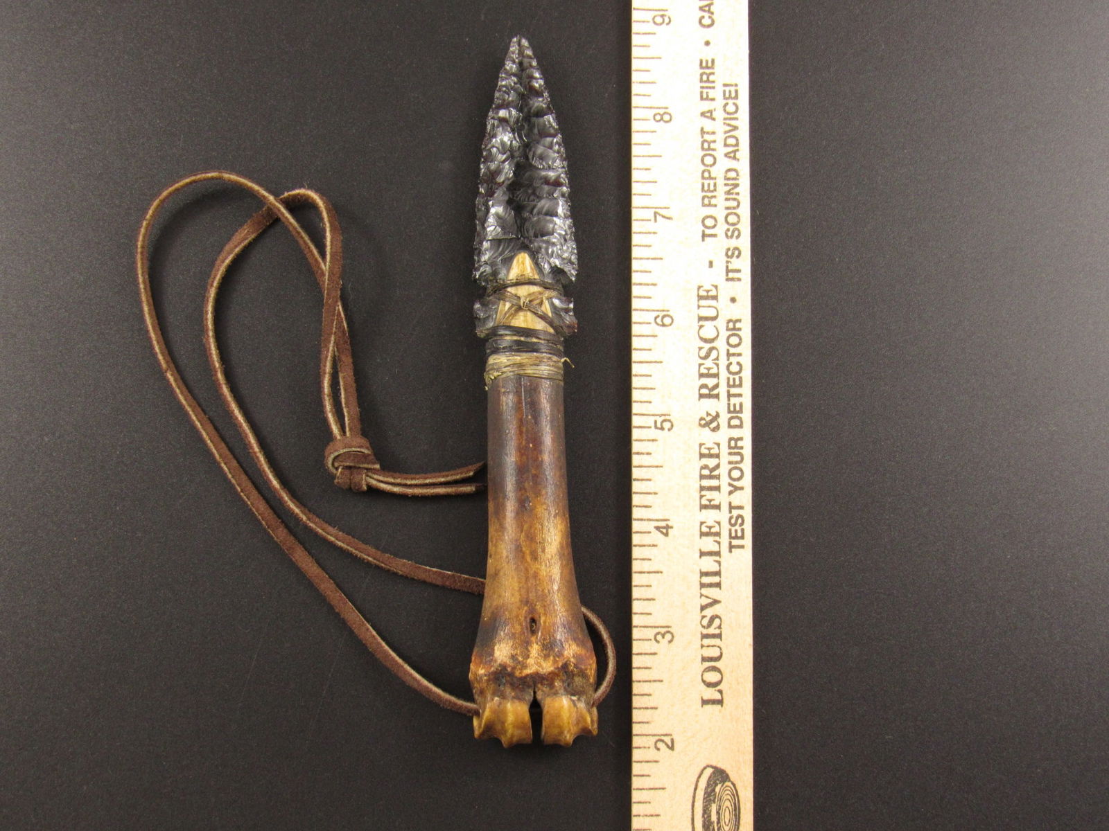 Decorative Obsidian Flint Knife With Bone Handle: Very nice decorative obsidian flint knife with bone handle. There is a leather strap threaded through the handle for wearing or displaying.