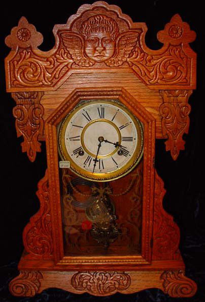 Waterbury Clayton Antique Kitchen Clock: Waterbury Kitchen Clock, "Clayton" model with original paper labels on back. 8 Day, Spring Strike, Strikes-Half-Hours. Waterbury Clock Company, Waterbury Conn. Oak Pressed case depicting Cherub's head