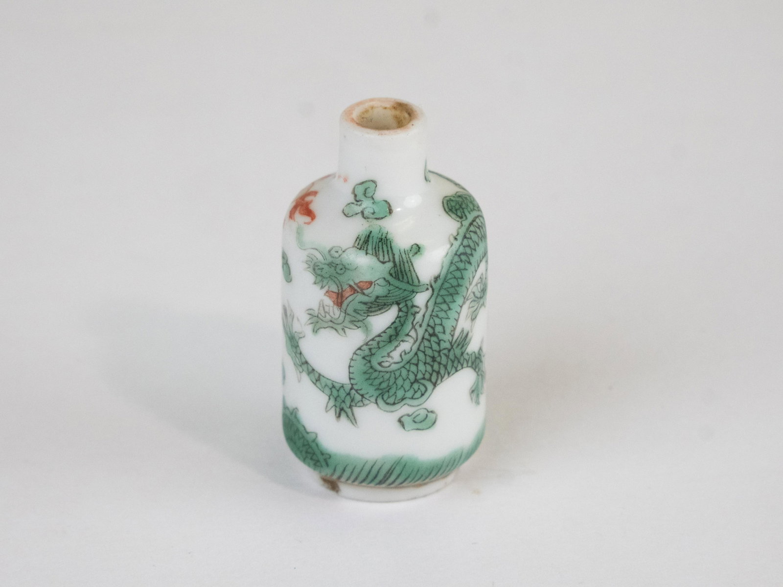 A Chinese Famille Rose Porcelain Snuff Bottle~ Daoguang Period: A Chinese Famille Rose Porcelain Snuff Bottle~ Daoguang Period. Bottle is decorated with a pair of dragons in pursuit of a flaming pearl amidst flames and cloud. Snuff bottle measures approx. 1 9/16&r