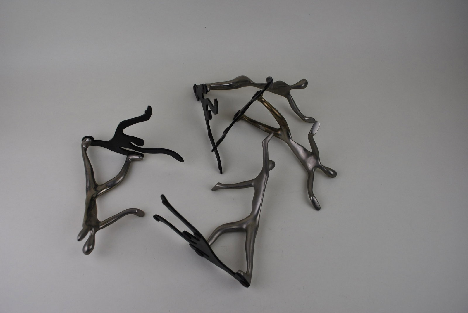 Mukul Goyal Design for CB2 modernist chrome man shadow bookends: Mukul Goyal Design for CB2 modernist chrome man shadow bookends. Measure approx. 9 1/4” tall X 4” wide.