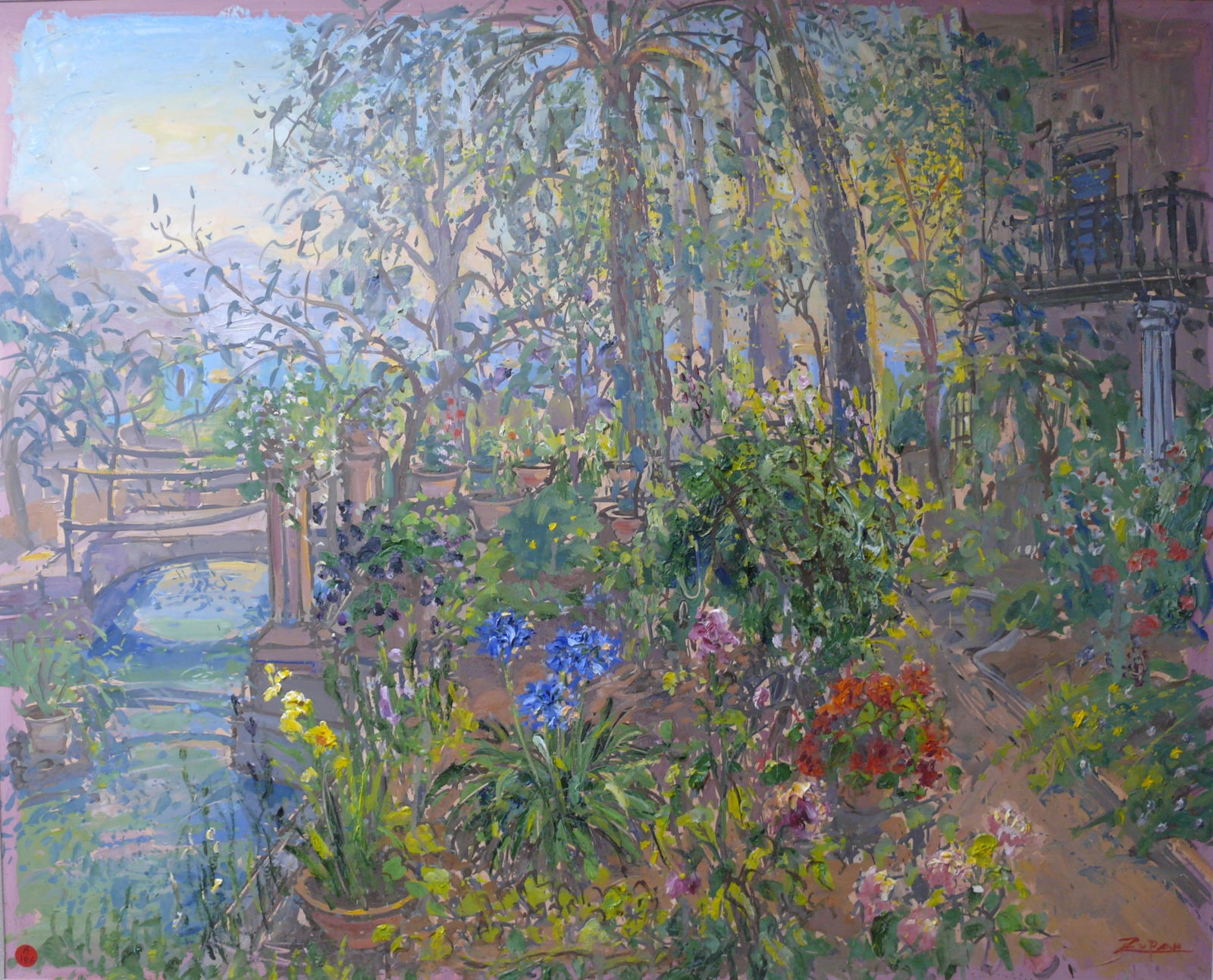 Bruno Zutan – Garden Landscape With Bridge and Cottage: Outdoor garden scene featuring a small stream, stone bridge on the left, cottage on the right, and vivid blue and red flowers centered in the composition. Lush Mediterranean palette typical of Zutan.