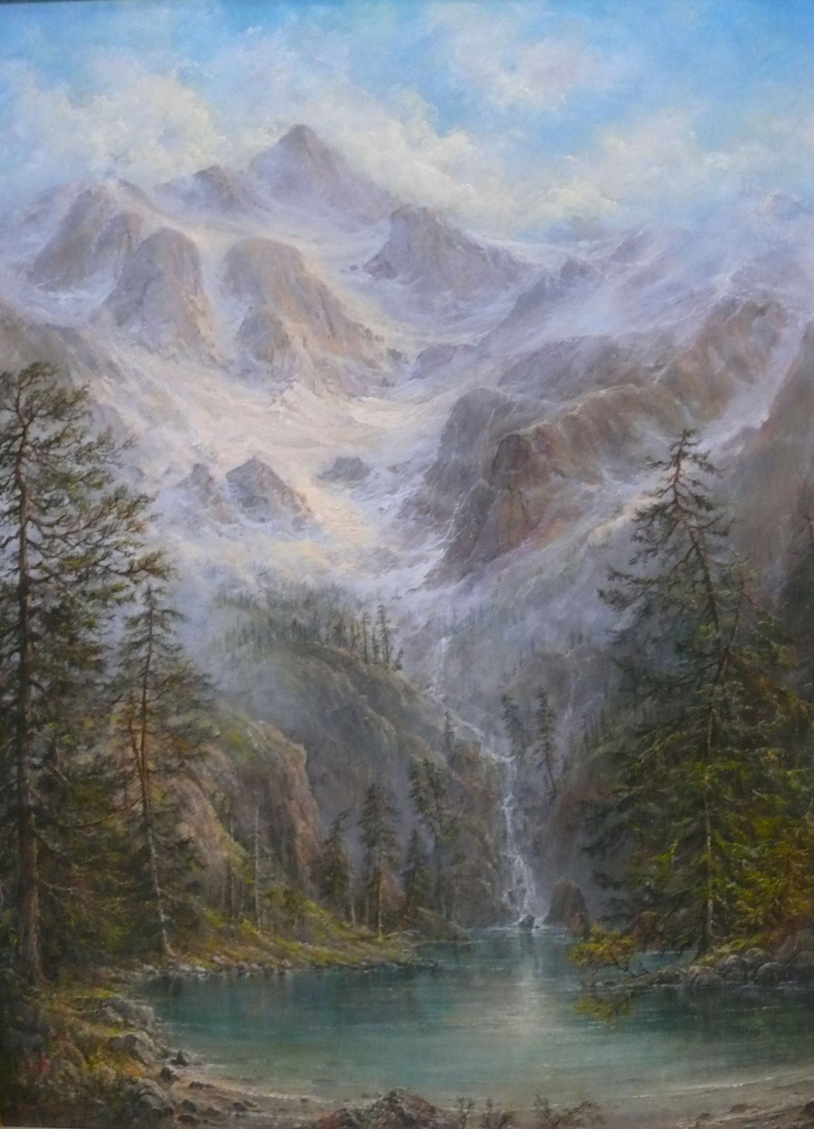 Ron Nicalaides — Mountain Lake with Waterfall: Serene mountain landscape with misty peaks in the background, a sparkling lake in the foreground, a cascading waterfall, and tall green trees framing the scene. Atmospheric depth and naturalistic deta