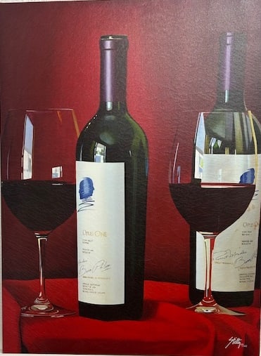 Stiltz —A Toast to Opus: Still life of two red wine bottles and two half-full glasses resting on red fabric; rich reds and reflective highlights create a celebratory, intimate composition Stiltz is a contemporary still-life