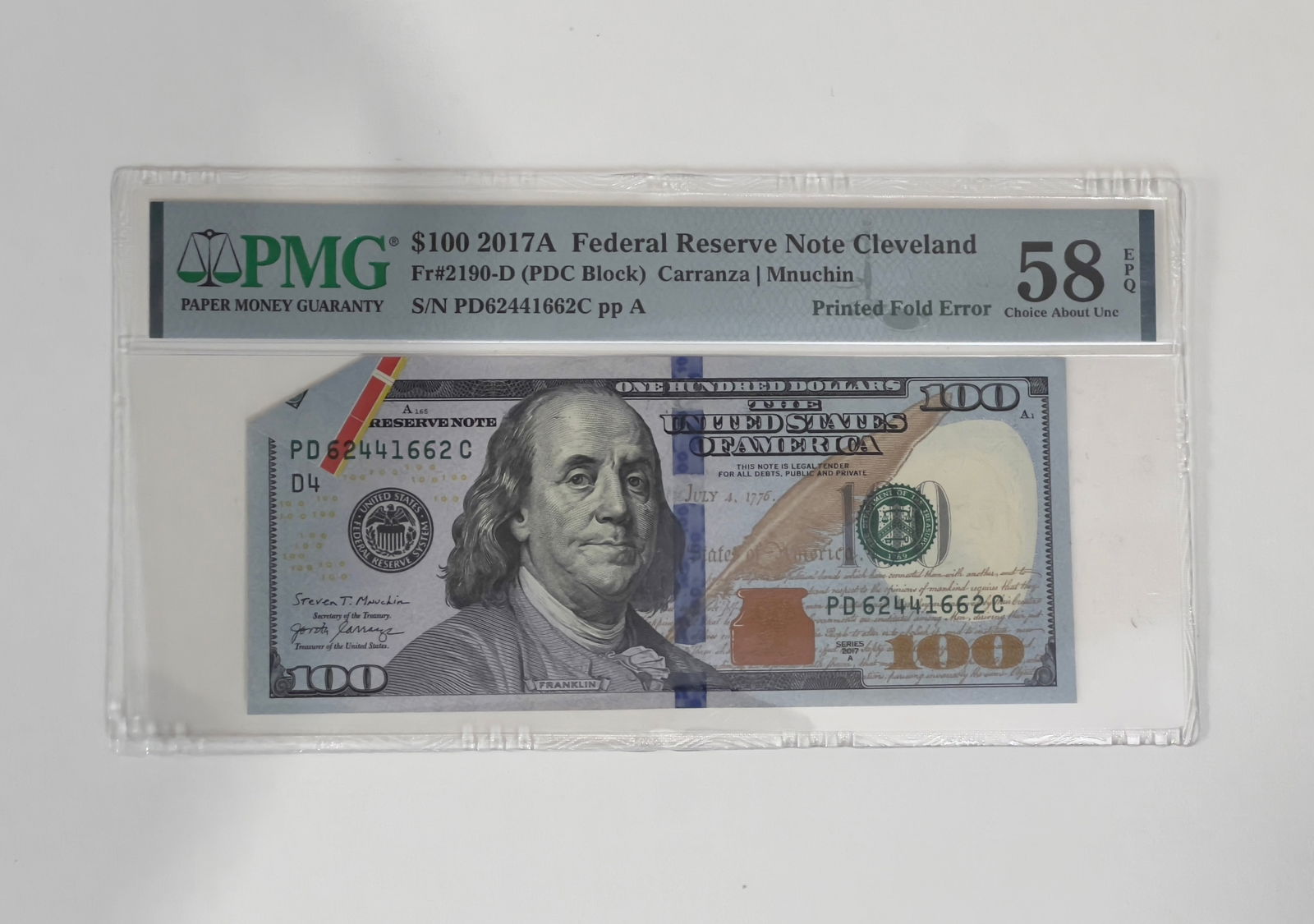 2017A $100 FRN Printed Fold Error PMG 58 EPQ Note: Offered is a 2017A $100 Federal Reserve Note from the Cleveland district featuring a dramatic printed fold error, where the paper was folded during the printing process, leaving part of the design