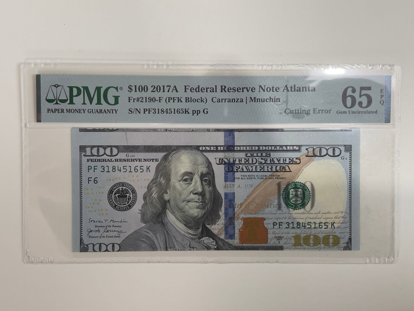 2017A $100 FRN Cutting Error Adjacent Note PMG65: Offered is a striking 2017A $100 Federal Reserve Note from the Atlanta district displaying a dramatic major cutting error, where the note was improperly cut during the finishing process. The miscut