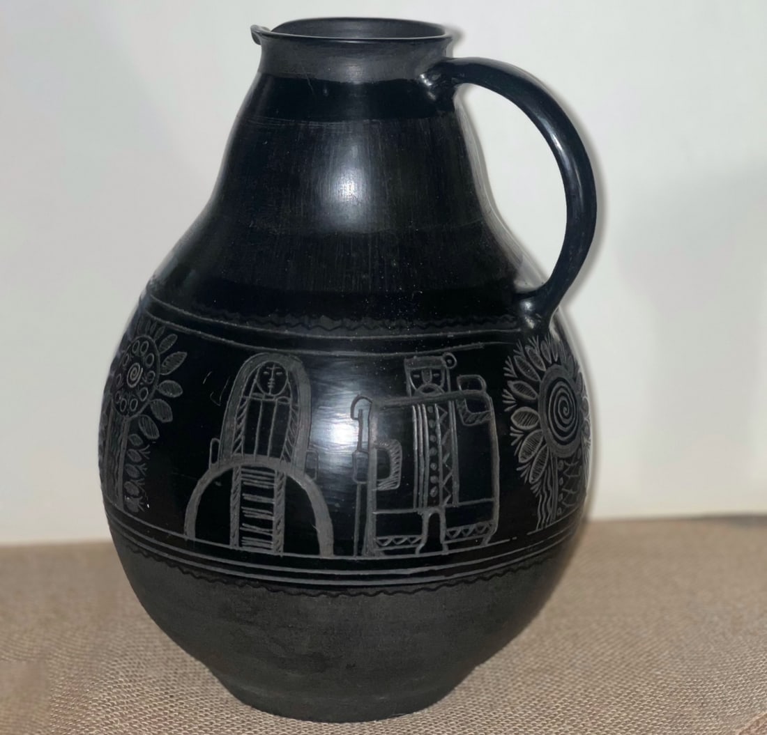 Erika Komonyi (Ukrainian Hungarian artist) — Midnight Etched Pitcher: Ceramic- A large and visually commanding black ceramic pitcher by Erika Komonyi, hand-formed from thick, substantial pottery. The piece is defined by its strong, sculptural presence, balanced by