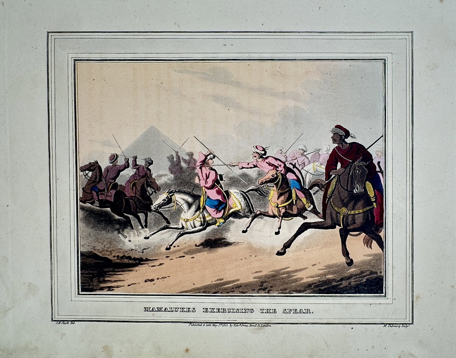 John Heaviside Clark (1771–1863) – Mamelukes Exercising the Spear – Hand-coloured aquatint: "Mamelukes Exercising the Spear" depicts a group of Mameluke cavalrymen on horseback engaged in military training with spears against a desert landscape featuring a pyramid in the background. This han