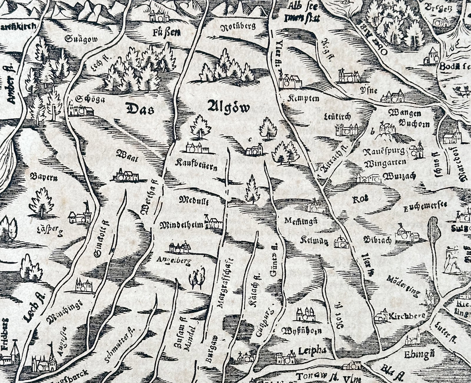 Sebastian Münster (1488–1552) – Map of Allgäu – Germany – Woodcut (1550): "Das Algöw" provides a topographical overview of the Allgäu region in southern Germany, featuring towns such as Kempten, Memmingen, and Kaufbeuren amidst a mountainous landscape. This woodcut map is