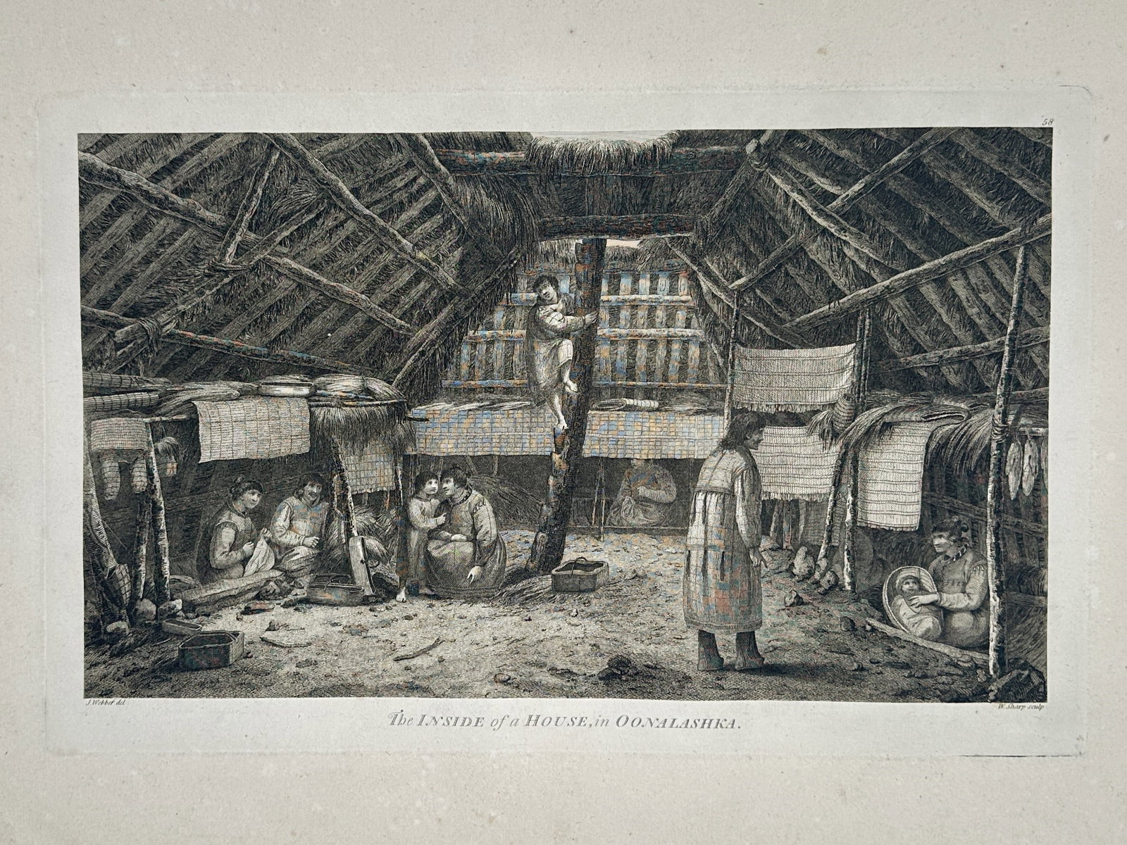 John Webber (1751-1793) – The Inside of a House in Oonalashka – Hand-coloured engraving (1784): "The Inside of a House in Oonalashka" illustrates the interior architecture and domestic life within a traditional dwelling on Unalaska Island. The scene documents residents engaged in daily activitie
