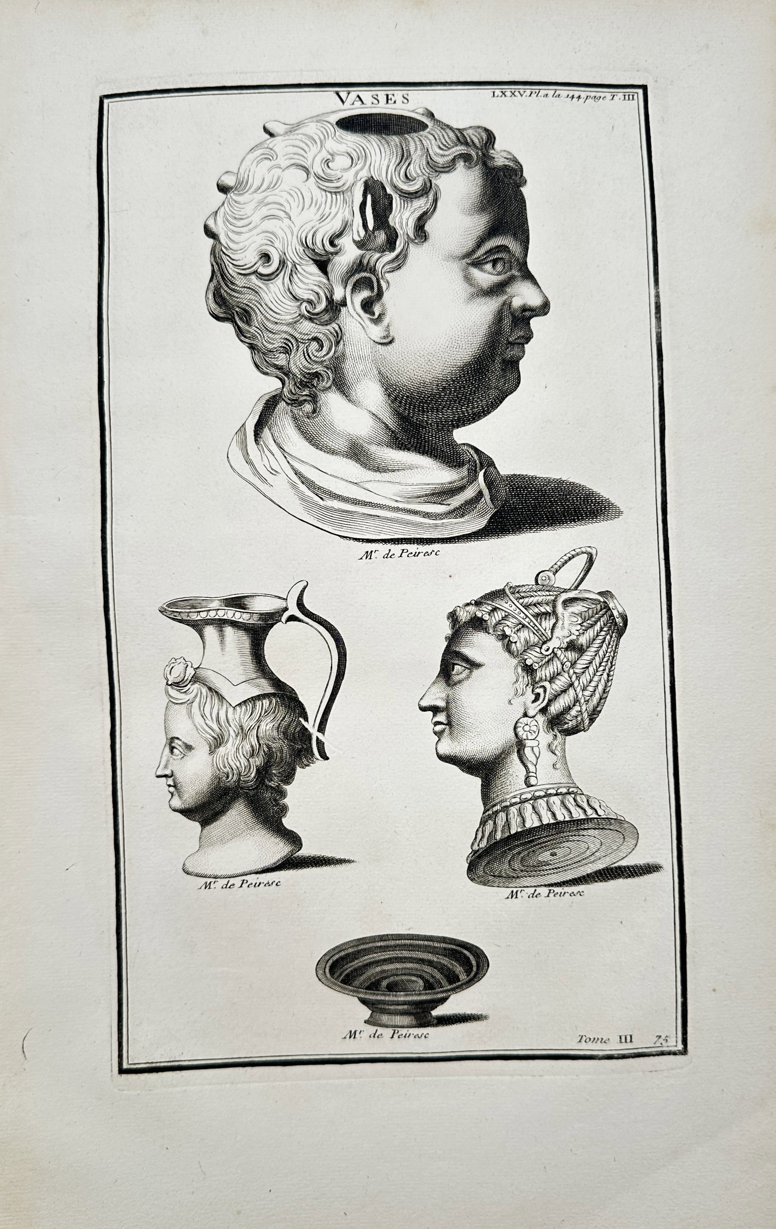 Bernard de Montfaucon – Ancient Roman Vases and Head Vessels – Engraving (18th Century): "Ancient Roman Vases and Head Vessels" presents an archaeological study illustrating classical Roman ceramic and bronze vessels shaped in the forms of human heads and busts alongside a shallow pedesta