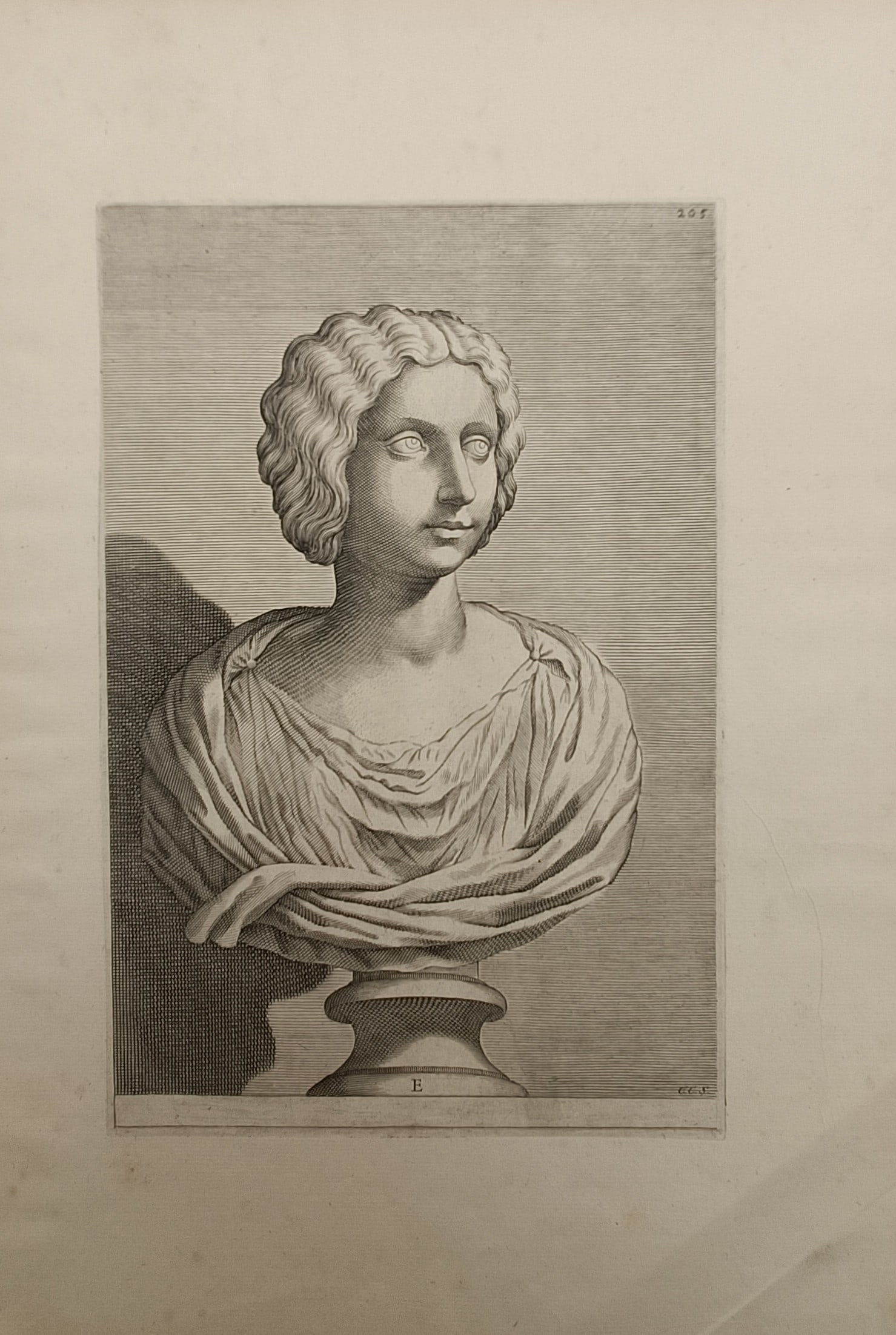 Unknown Artist – Classical Female Bust – Engraving (18th Century): "Classical Female Bust" depicts a reproductive print of a sculpted marble portrait featuring a young woman with wavy parted hair and elegant drapery resting upon a turned pedestal. The antiquarian com