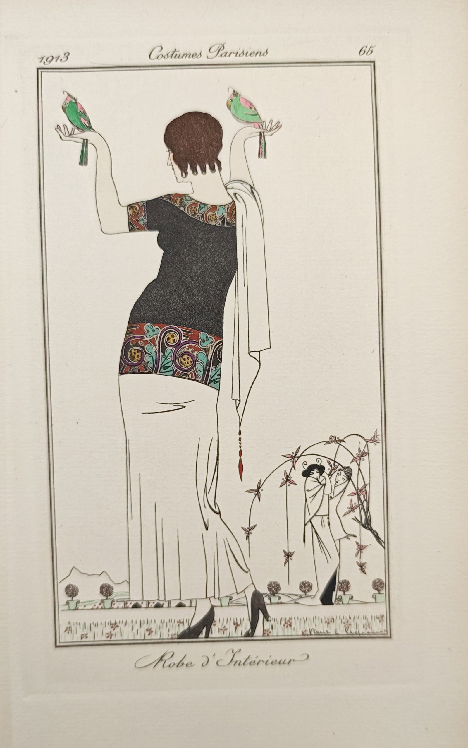 Pierre Legrain – Indoor Dress – Pochoir (1913): "Indoor Dress" presents an early Art Deco fashion illustration depicting an elegant woman attired in an ornate indoor gown holding two colorful birds perched upon her hands. The pochoir was published 