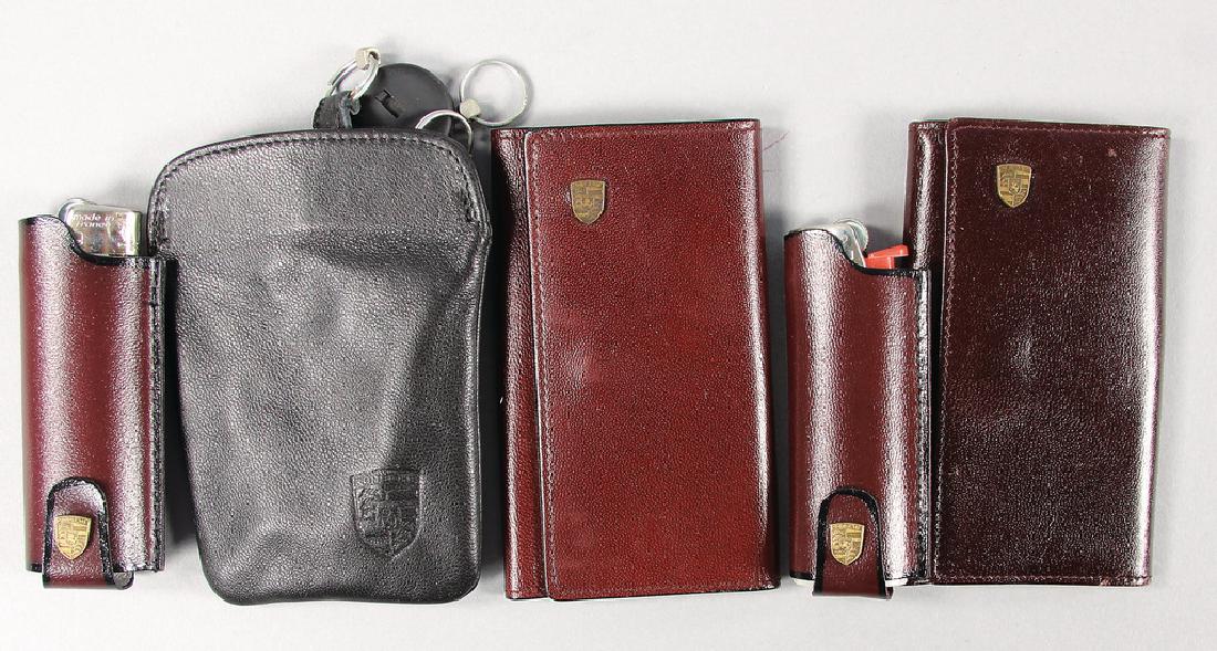PORSCHE Mixed lot with 5 pieces, key pendants from the: PORSCHE Mixed lot with 5 pieces, key pendants from the '80s in black and also 2 key pendants in wine-red and 1 leather coating for lighters, condition 1-2 German Description PORSCHE, Konv. 5tlg., Schl