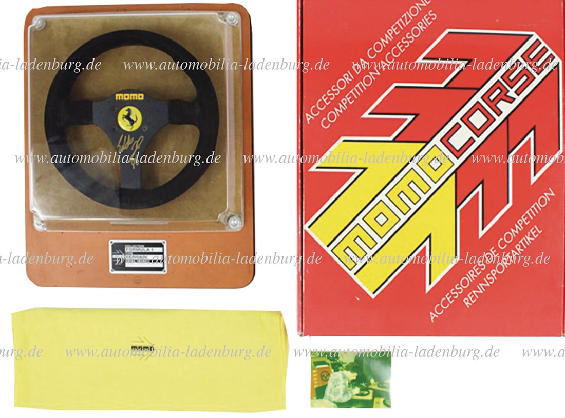 FERRARI / MOMO handsigned replika Ferrari F1 steering wheel (MOMO), signed by Eddie Irvine, on a: FERRARI / MOMO handsigned replika Ferrari F1 steering wheel (MOMO), signed by Eddie Irvine, on a leather display (Schedoni), signature dated 1996, with original box, and photo German Description FERRA