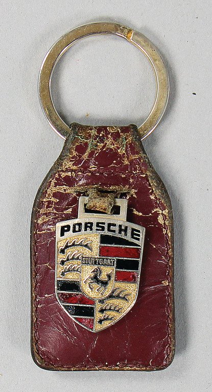 PORSCHE '80s, wine-red leather-key pendants with: PORSCHE '80s, wine-red leather-key pendants with Porsche emblem made of enamel, key ring was later attached German Description PORSCHE 80er Jahre, weinroter Leder-Schlüsselanhänger mit Porsche Emble