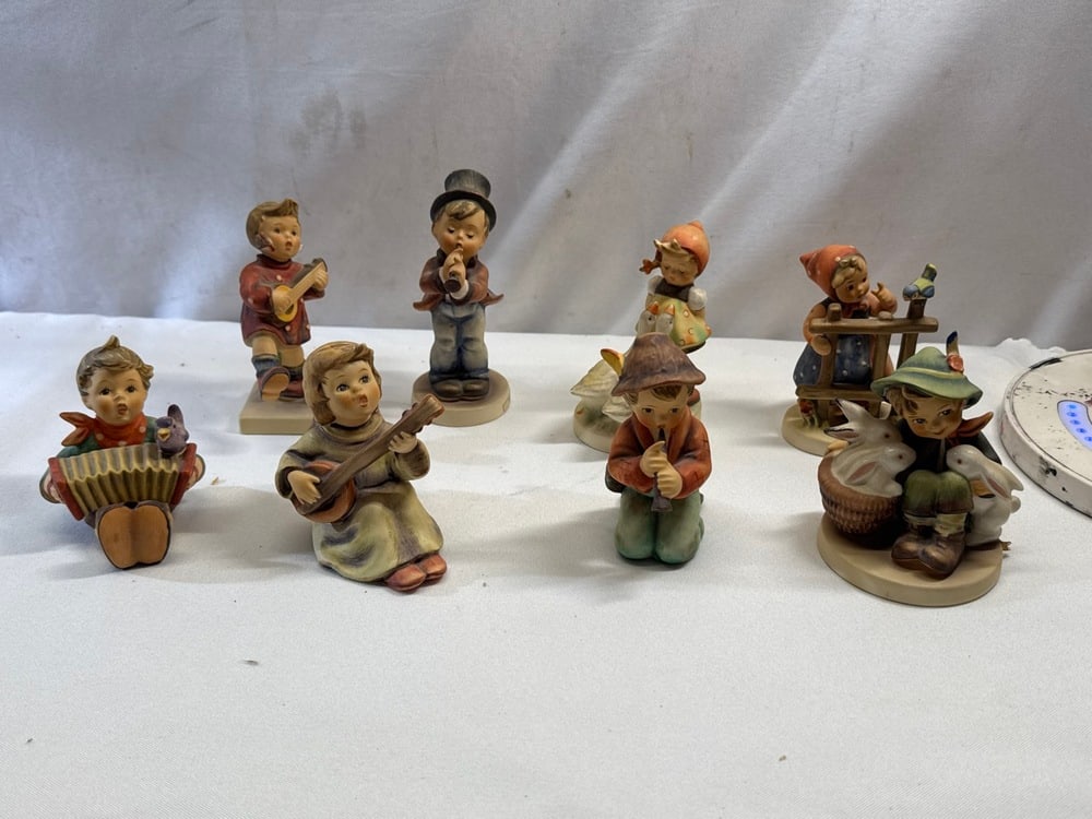 8 Vtg. Goebel Hummel Figurines: 8 Vtg. Goebel Hummel Figurines - Signs of Spring 203 2/0, Playmates 58/0, Goose Girl 47 2/0, Little Tooter 214/ 4, Serenade 85/0 , Sounds Of the Mandolin 438, Let’s Sing 110/0 and Happiness 86