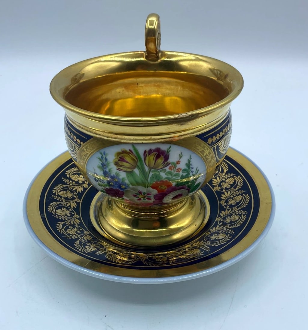 Old Paris Porcelain Large Cup And Saucer In Cobalt Blue,richly Gilded And Painted With Flowers: Magnificent large tea cup and saucer. hand painted with a bouquet of flowers. Richly gilded from inside and foliage on the plate and all around the cup.Cup is measures 10cm high and 10cm across the ri