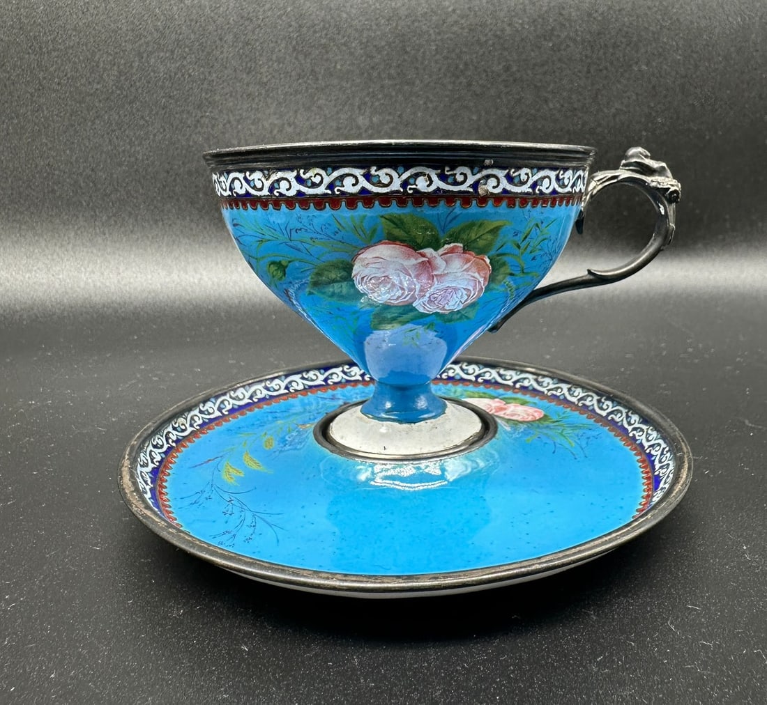 Russian Ovchinnikov silver enamel cup and saucer,very unusual and rare. Marked: On the blue background hand painted with pink roses and green leaves.Condition: Small chip on the metal from inside,can be restored.Measures: 8,3cm highWidth across the rim: 8.5cmWidth of the plate: 1